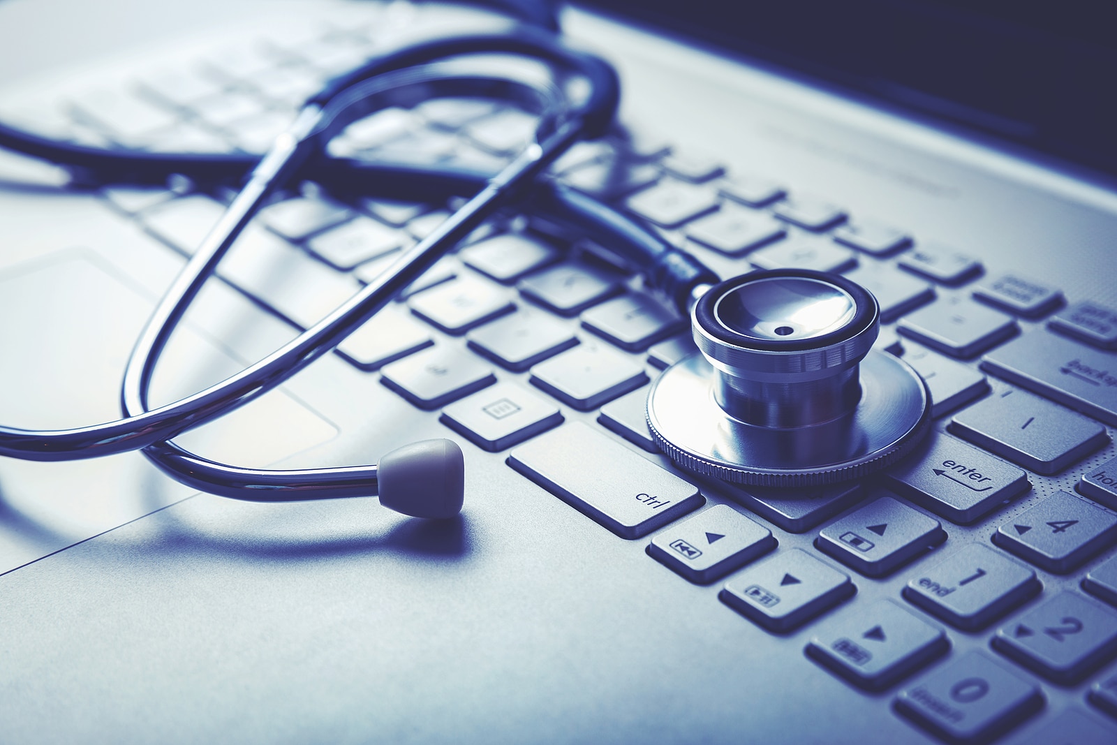 medical stethoscope on laptop keyboard. computer diagnostic or e-health concept